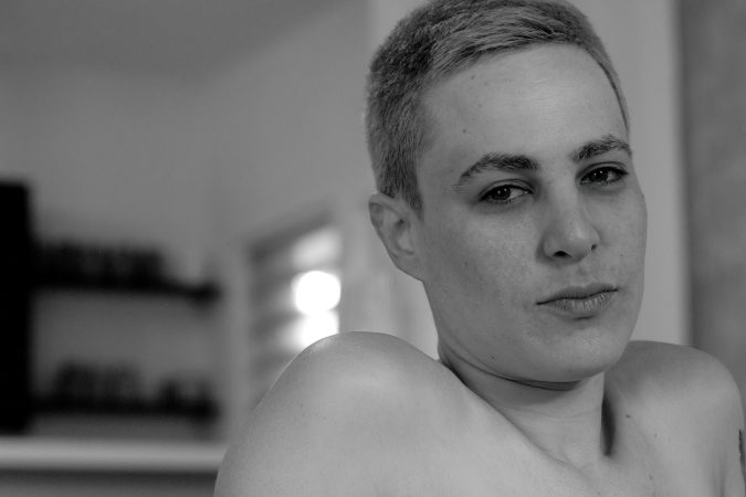 Black and white portrait of a person with short hair looking at the camera.