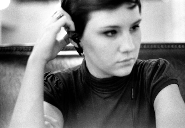 Black and white portrait of a young woman looking away thoughtfully.