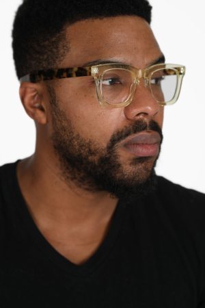 Close-up of a man with glasses and a beard looking thoughtfully to the side.