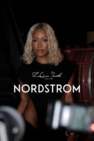 Fashion model posing with Nordstrom branding in a dark setting.